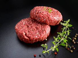 Home HandMade Raw Minced Beef steak burgers on black board.